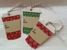 three christmas gift tags are hanging from twine