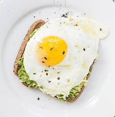 an egg and avocado sandwich on a white plate