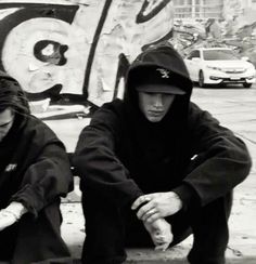 two people sitting on the ground with their hands together