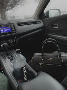 the interior of a car with a handbag and water bottle