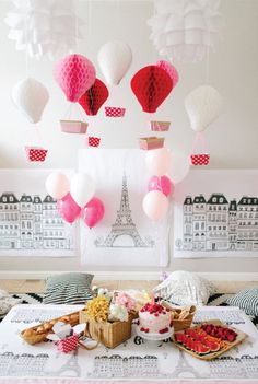 a table topped with lots of desserts and balloons in the shape of hot air balloons