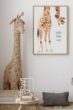 a giraffe standing next to a baby's room with a poster on the wall