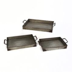 three metal trays sitting on top of each other in front of a white background