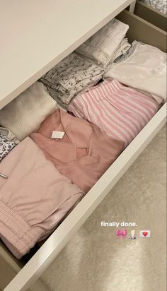 an open drawer with clothes in it