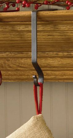 a piece of cloth hanging from a hook on a wooden rack with red string attached to it