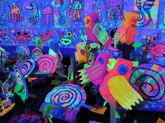 brightly colored paper birds are on display in a room with blue and purple walls,