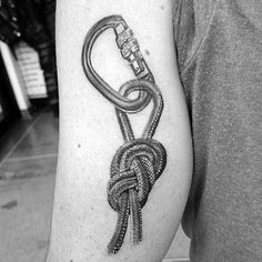 a black and white photo of a man's arm with a knot tattoo on it