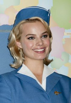 a woman in a blue uniform smiling for the camera