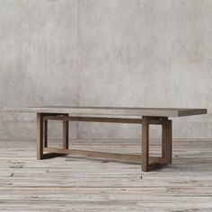 a wooden table sitting on top of a hard wood floor next to a white wall