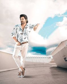 a man standing on top of a cement floor next to a white wall and clouds