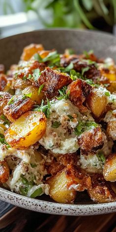 a bowl filled with potato salad on top of a wooden table