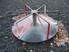 a broken fire hydrant sitting on top of a parking lot next to leaves and trees