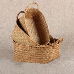 three straw baskets stacked on top of each other in the shape of a basket with handles