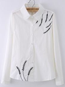 a white shirt with black embroidery on it