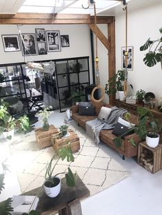 a living room filled with furniture and lots of plants on top of wooden pallets