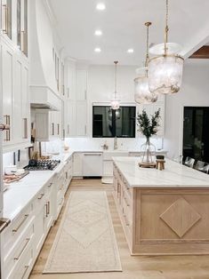 a large kitchen with white cabinets and marble counter tops