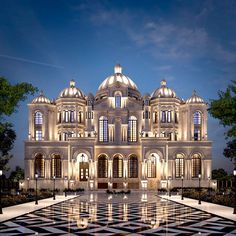 a large white building with many windows and lights on it's front facade at night