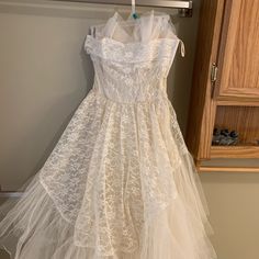 a white dress hanging on a clothes rack