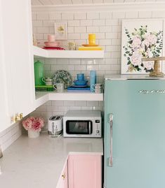 a blue refrigerator freezer sitting inside of a kitchen next to a microwave and toaster oven