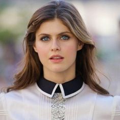 a woman with blue eyes wearing a collared shirt