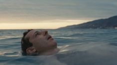 a man swimming in the ocean with his eyes closed