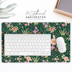 a computer keyboard and mouse pad on a desk with an image of flowers in the background