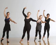 four women in black leotards are posing for the camera with their arms up