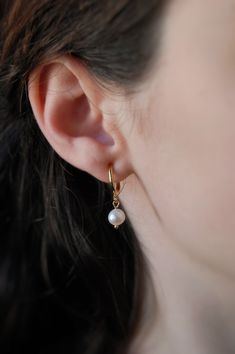 These dainty earrings are made with freshwater pearls and gold or platinum plated huggie hoops. This plating protects against wear and tear, tarnishing, and light contact with substances such as water. Closures: * Standard gold hoops are hypoallergenic and nickel free (18 karat gold plated). * Standard silver hoops are hypoallergenic and nickel free (platinum plated). * Clip on gold hoops are hypoallergenic and nickel free (18 karat gold plated). * Clip on silver hoops are hypoallergenic and nic White Pearl Huggie Earrings In Dainty Style, Hypoallergenic Pearl Huggie Earrings, White Pearl Drop Huggie Earrings, Delicate Huggie Pearl Earrings With Charm, Everyday Pearl Charm Dangle Huggie Earrings, White Hypoallergenic Huggie Pearl Earrings, Hypoallergenic Huggie Pearl Earrings, Everyday Pearl Drop Dangle Huggie Earrings, Delicate White Hypoallergenic Huggie Earrings