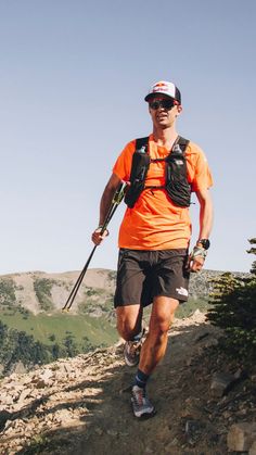 a man in an orange shirt is hiking