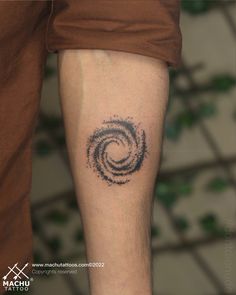 a man's arm with a tattoo on it that has a spiral design in the middle