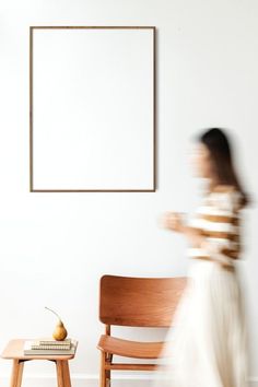 a woman in a white dress walking past a chair