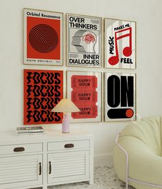 a room with posters on the wall and a white chair in front of it next to a lamp