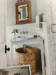 a bathroom with a sink, mirror and wicker basket