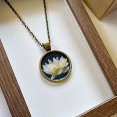 "This listing is for a one of a kind, hand painted lotus flower pendant necklace. The mini lotus painting was done in watercolor and acrylic and then finished with a clear varnish for protection. The pendant is 1\" wide, with a 20\" cable chain.  The lotus symbolizes purity, spiritual enlightenment and rebith 🤍 Please message me if you have any questions or to request a custom pendant necklace!" Hand Painted Nature-inspired Necklace For Gift, Nature-inspired Hand Painted Necklace For Gift, Hand Painted Flower Necklace For Gift, Hand-painted Flower Pendant Necklace For Gift, Hand Painted Flower Pendant Necklace As Gift, Hand Painted Spiritual Round Necklaces, Hand Painted White Round Pendant Necklaces, White Hand Painted Round Pendant Necklaces, White Hand Painted Round Pendant Necklace