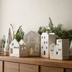 white ceramic houses are lined up on a shelf