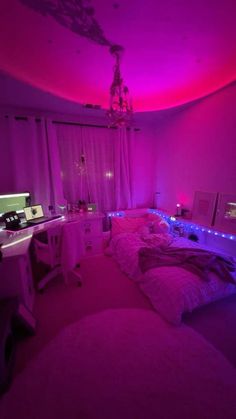 a bed room with a neatly made bed next to a computer desk and purple lights