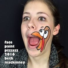 a girl with her face painted like a cartoon turkey, making a funny face for the camera