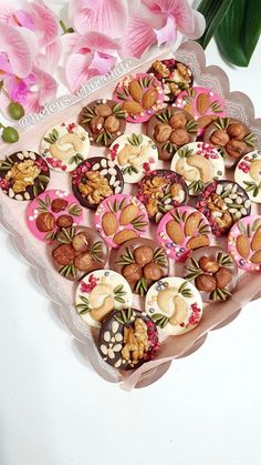 there are many cookies in the shape of hearts on this tray with flowers behind it