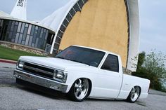 a white pick up truck parked in front of a building with a large round window