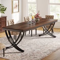 a dining room table with chairs and a rug on the floor in front of it