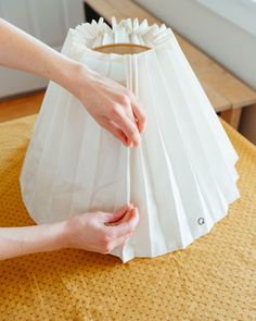 a person holding a white paper bag on top of a table