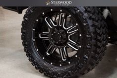 the front wheel and tire of a black four - wheeled vehicle with starwood tires