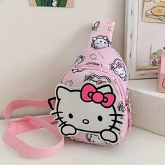 a pink hello kitty backpack sitting on top of a white counter next to a mirror