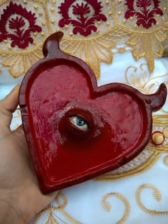 a red heart shaped object held in someone's hand