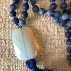 "Malas are a wonderful way to bring your love of crystals and meditation together. And if you can use them as jewelry, even better! This is a hand-made (by me) 108-bead 6mm mala, made with matte denim lapis beads and a rectangular opaline guru bead. It's hand-knotted with nylon cord, with a hand-made silk tassel. Approximately 30\". The beads are slightly smaller than most of the malas you see (which are 8mm) so it makes it small enough that it also works well as a necklace." Spiritual Moonstone Crystal Necklace With Gemstone Beads, Adjustable Crystal Necklaces With Round Beads For Healing, Mystical Crystal Necklaces With Round Beads For Gifts, Mystical Crystal Necklace With Round Beads For Gift, Spiritual Agate Crystals As Gift, Spiritual Agate Crystals For Gifts, Spiritual Agate Crystals, Bohemian Hand Wrapped Mala For Meditation, Adjustable Gemstone Beads Crystal Necklace For Healing