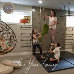 two children and an adult are playing on the floor in a room with hanging objects