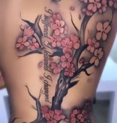 the back of a woman's body with pink flowers and words on her chest