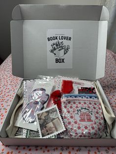 an open box filled with lots of different items on top of a cloth covered table