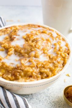 a bowl of oatmeal next to a glass of milk