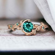 a green ring with leaves on it sitting on top of a piece of cloth next to a